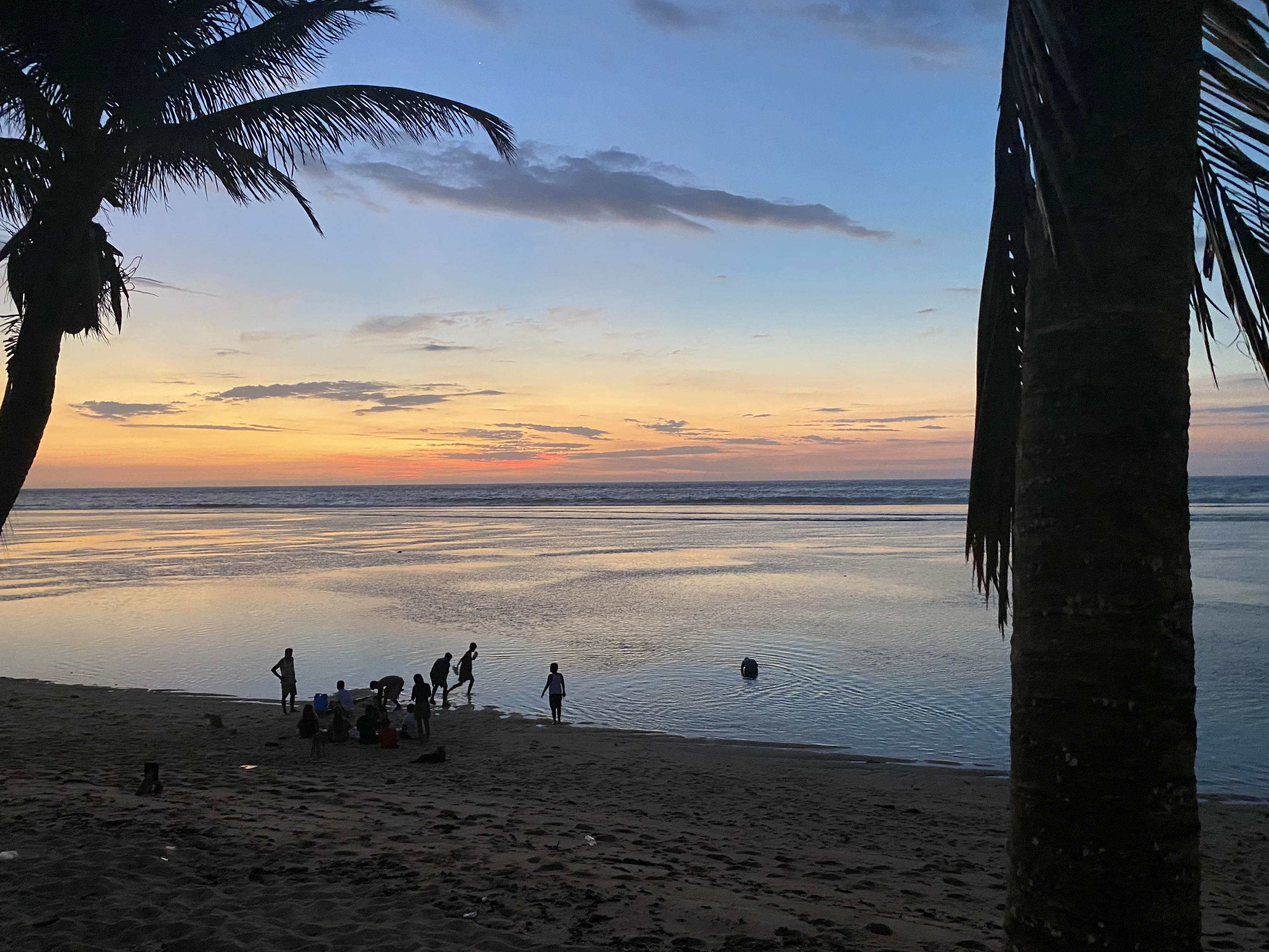 Children playing in the surf at sunset, Bolinao